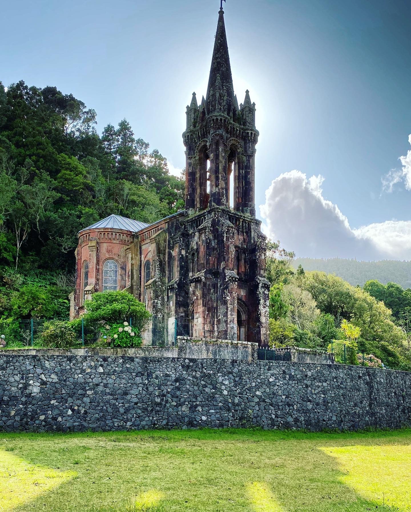 The same chapel from close up, its stone spire rising against the sun