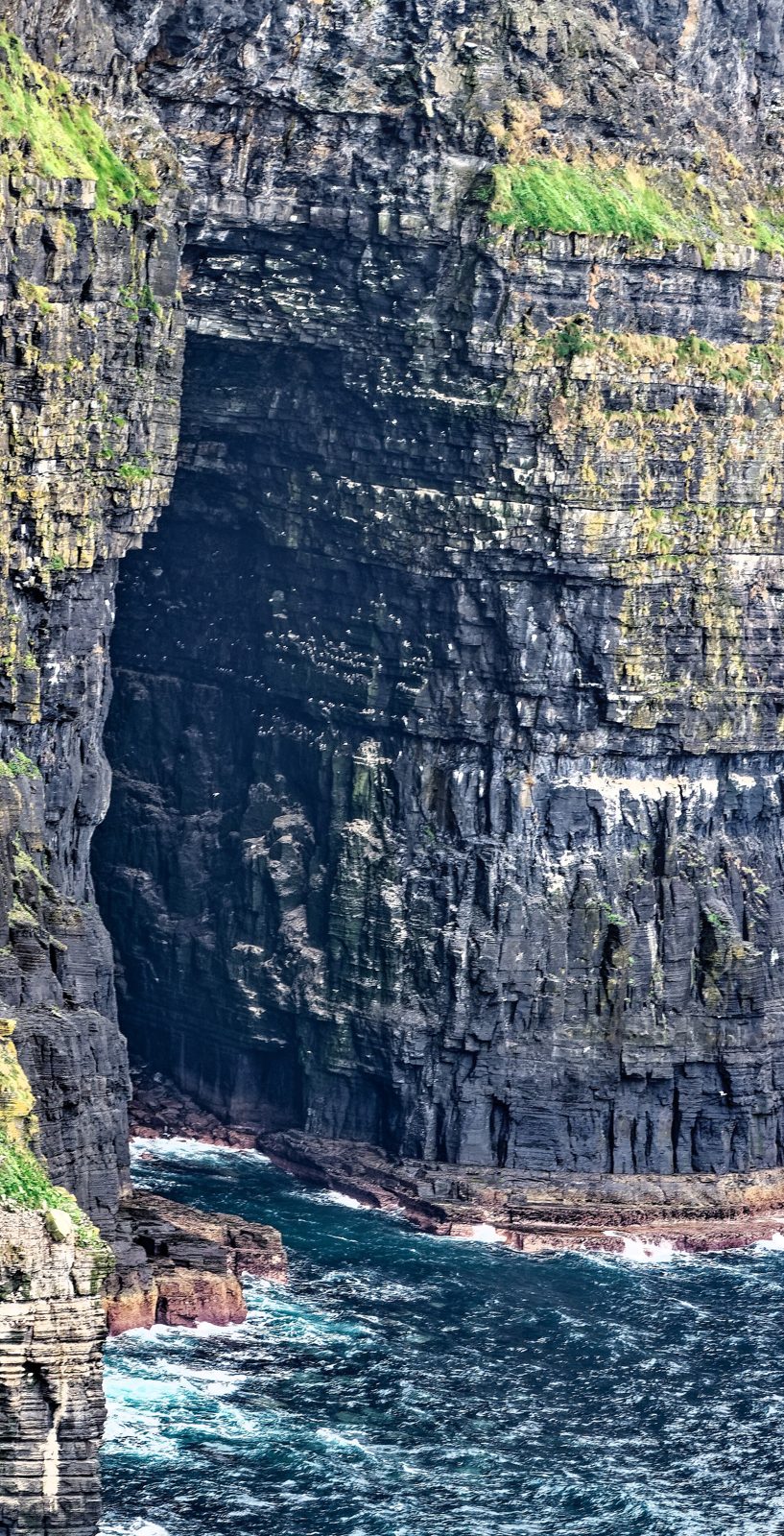 The Cliffs of Moher on the west coast of Ireland, dark layered rock dropping straight into the Atlantic
