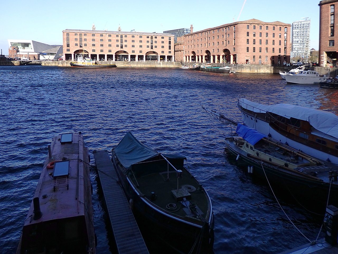 The Albert Dock in Liverpool, red brick warehouses with cast iron columns standing around still dock water