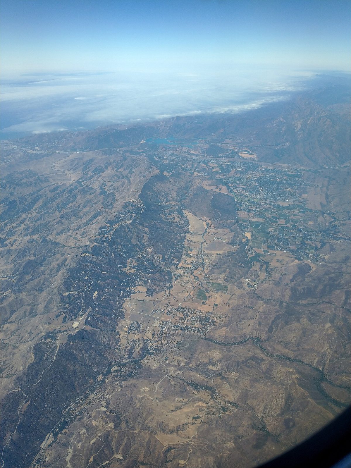 The Ojai valley in California from the air, orchards and low houses between dry mountains