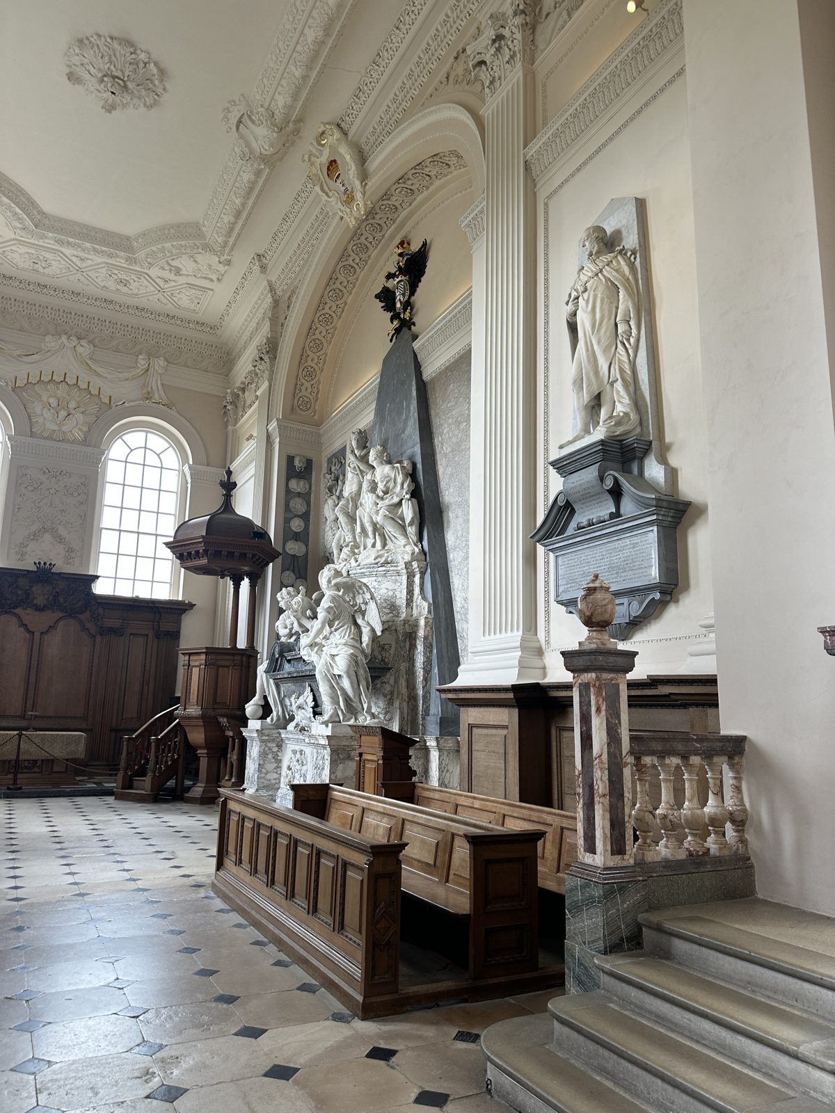 The chapel at Blenheim, with the marble Marlborough monument of standing figures rising against the wall under moulded plaster vaulting
