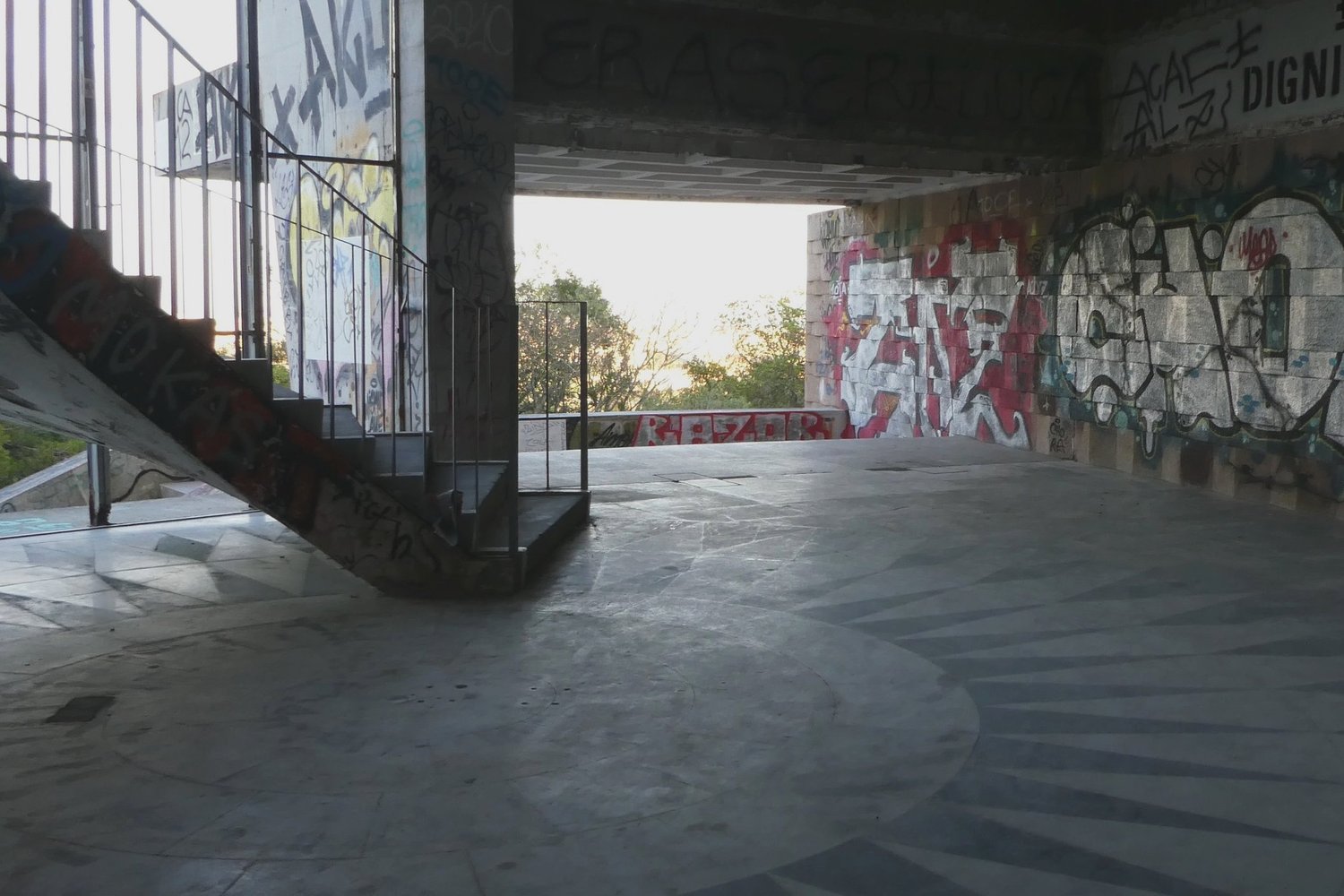The empty curved floor of the old restaurant, its concrete walls covered in layers of graffiti
