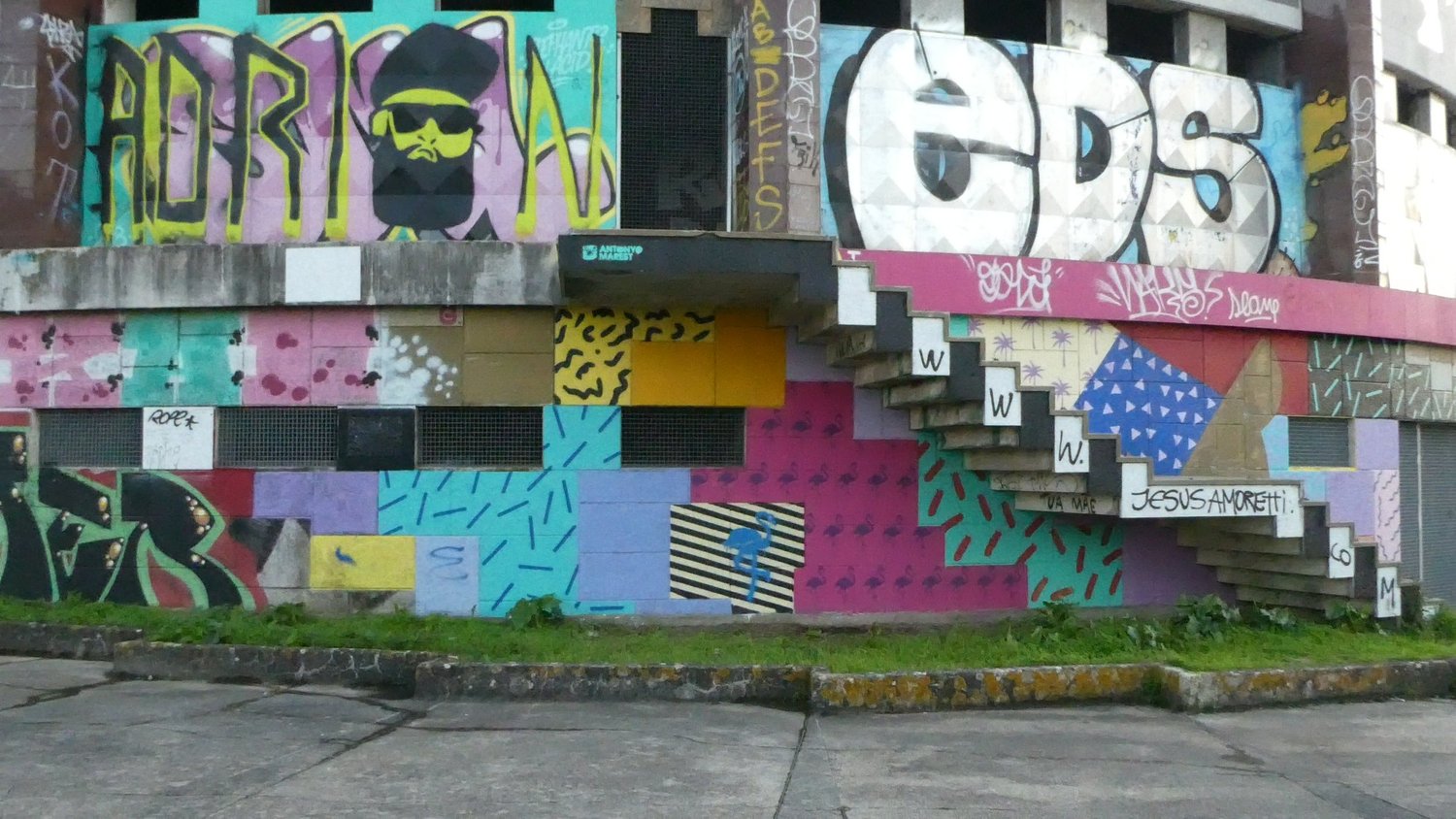 The exterior of the Panorâmico de Monsanto covered in bright graffiti murals beneath its cantilevered concrete stairs