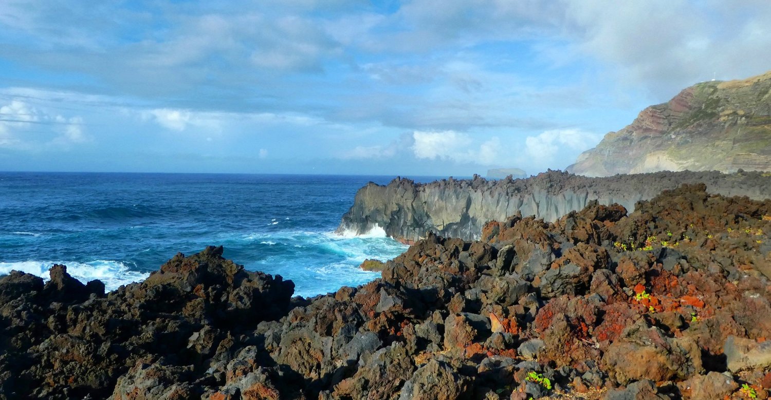 Waves breaking against the black volcanic rock and cliffs of Ponta da Ferraria on Sao Miguel in the Azores